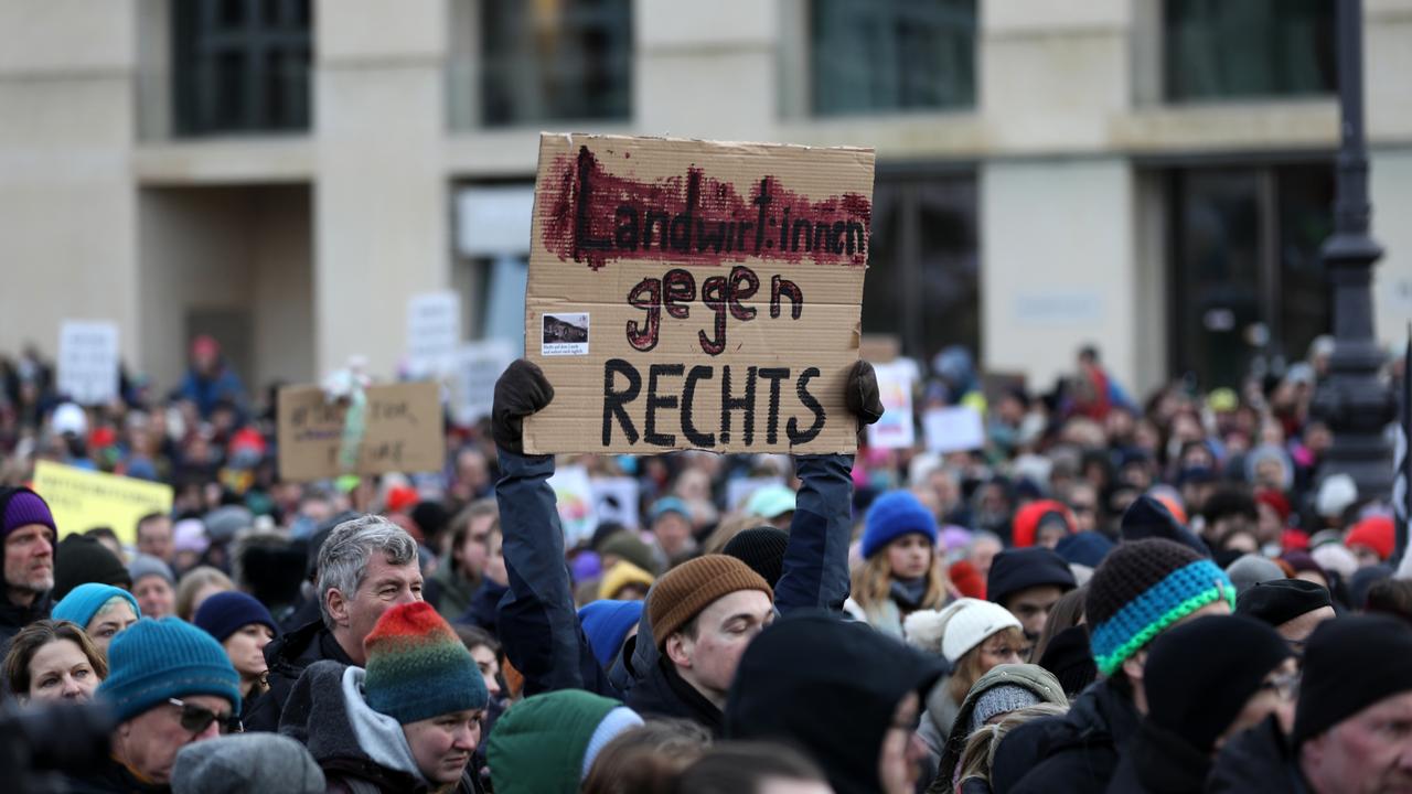 A girl holds a sign reading, 