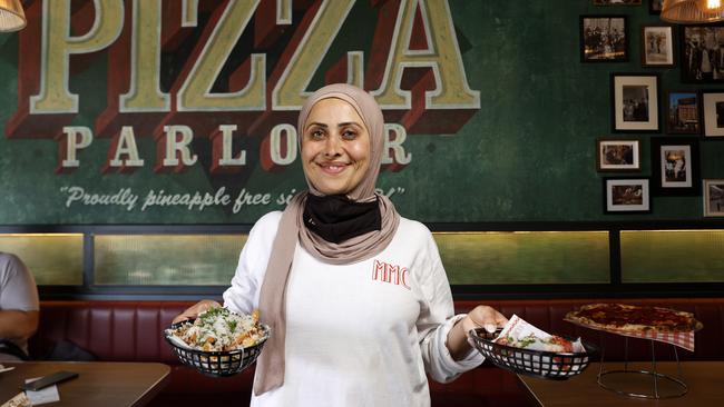 Amani Rachid, co-owner of My Mother’s Cousin in Bexley North, with their arancini and fries with chicken gravy and grated parmesan. Picture: Jonathan Ng