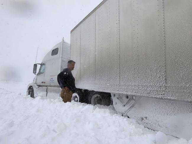 Help! ... Omer Odovsc looks over his tractor trailer that got stuck on the 219 off ramp leading to Route 391 in Boston, New York. Pic: AP Photo/The Buffalo News, Harry Scull Jr.