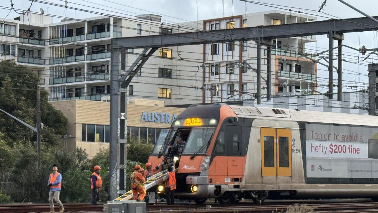 Parts of a train’s rooftop power connecter became tangled with overhead powerlines, bringing the lines onto the track near Homebush just before 2.30pm on Tuesday.