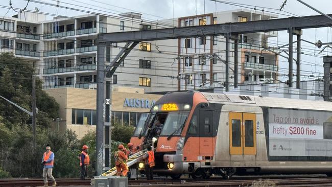 Parts of a train’s rooftop power connecter became tangled with overhead powerlines, bringing the lines onto the track near Homebush just before 2.30pm on Tuesday.