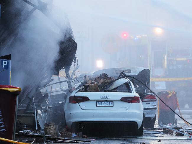 Cars outside the destroyed building. Picture: John Grainger