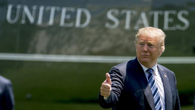 President Donald Trump give a thumbs up to members of the media as he arrives on the South Lawn of the White House in Washington.