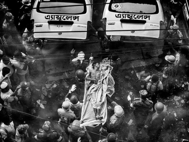 Rescuers carry a survivor pulled out from the Rana Plaza rubble after 77 hours. On 24 April 2013, an eight-story building collapsed in Savar, killing more than 1,100 workers and injuring over 2,500. Picture: Rahul Talukder