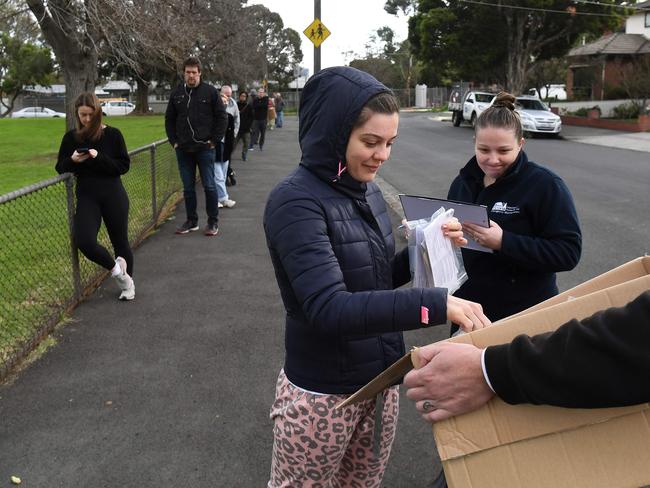 A health worker hands out test kits in the Melbourne suburb of Brunswick West. Picture: AFP