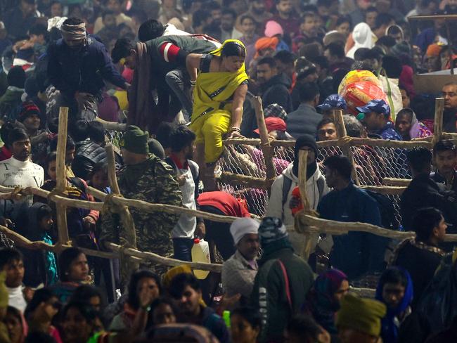 A woman climbs a fence amid the ongoing Maha Kumbh Mela festival in Prayagraj. Picture: AFP