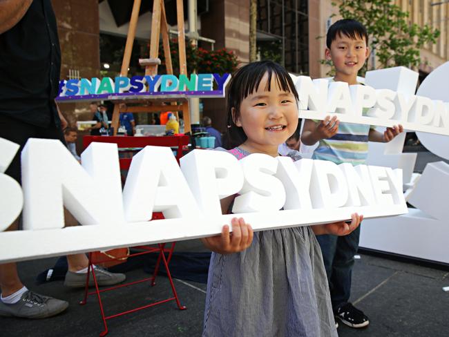 Sophie Xu, 3, and Paul Wan, 7, wait for their #SnapSydney signs to be painted at Snap Sydney's prevent at Martin Place. Adam Yip