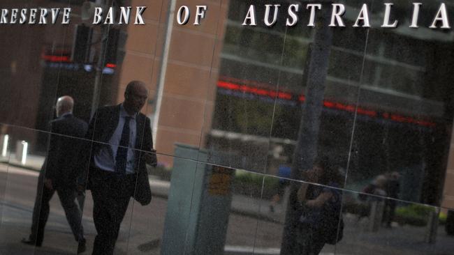 A passerby is reflected on a wall of the Reserve Bank of Australia in Sydney on February 3, 2015. Australia's central bank on February 3 lowered its key interest rate by 25 basis points to a new record low of 2.25 percent, saying after a year-and-a-half on hold the cut was justified to spur growth. AFP PHOTO / Saeed KHAN