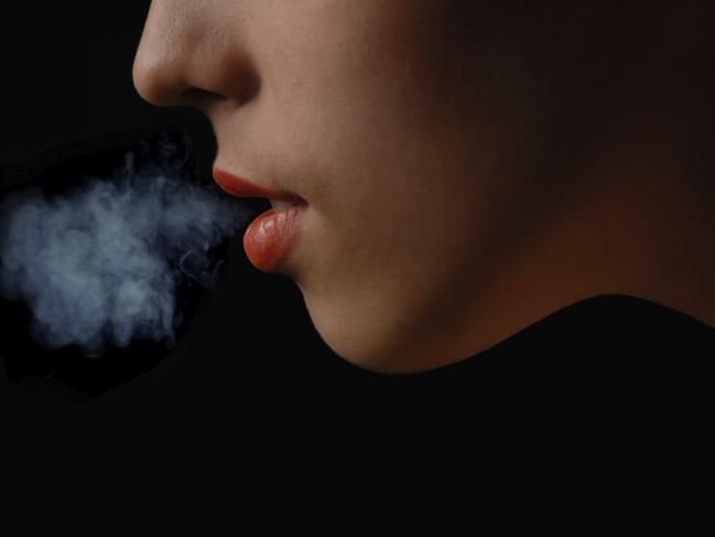 Half-face of the smoking woman on a black background