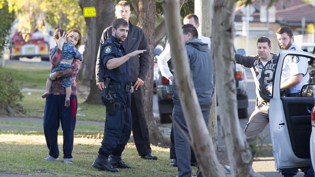 An unknown woman comforts the man’s child (left) after the boy was pulled from the truck by police.