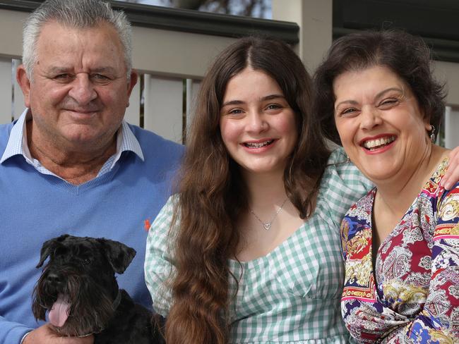 ADELAIDE 6 August 2022 - Sue Tselikidis at home in Semaphore with 12 year old daughter Stavroula, husband Lucky, and dog ÃShortyÃ. Sue had a CT scan due to family history of heart attacks, to check if she had any plaque - it found a 90 per cent blockage so immediate action with a stent inserted, saved her life. Picture Dean Martin/Advertiser/Sunday Mail