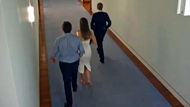 Brittany Higgins and Bruce Lehrmann walking down a corridor in Parliament House.