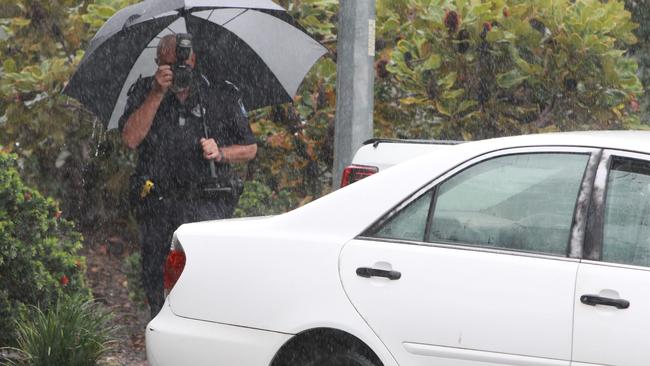 Police inspect the car where the two victims were found. Picture: Mike Batterham.