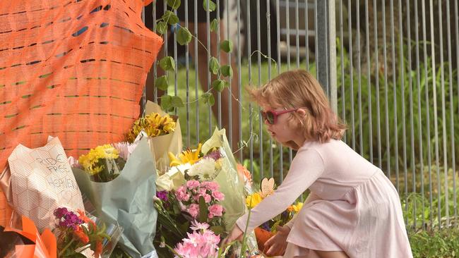 Memorial rally for Jennifer Board near the accident site on Ross River Road, close to Weir State School. A girl places flowers near the accident site. Picture: Evan Morgan