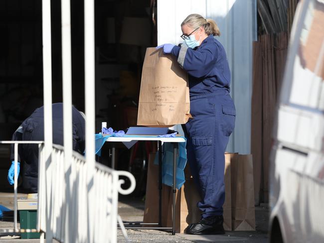 Police examine rubbish from the bins in Coolaroo. Picture: David Crosling