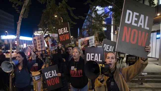 Protesters in Tel Aviv hold signs and photos of hostages, calling for a hostage deal.