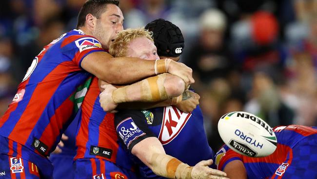 Bulldogs prop James Graham gets an offload away against the Knights at McDonald Jones Stadium. Picture: Gregg Porteous