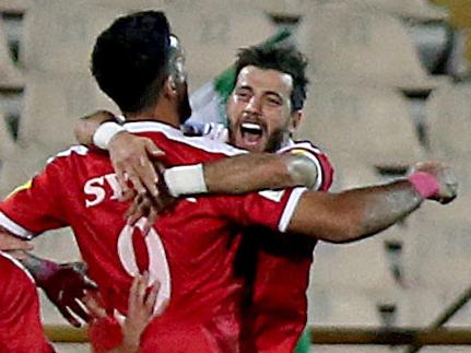 Syria's players celebrate after scoring a goal against Iran during the FIFA World Cup 2018 qualification football match between Iran and Syria at the Azadi Stadium in Tehran on September 5, 2017. / AFP PHOTO / ATTA KENARE