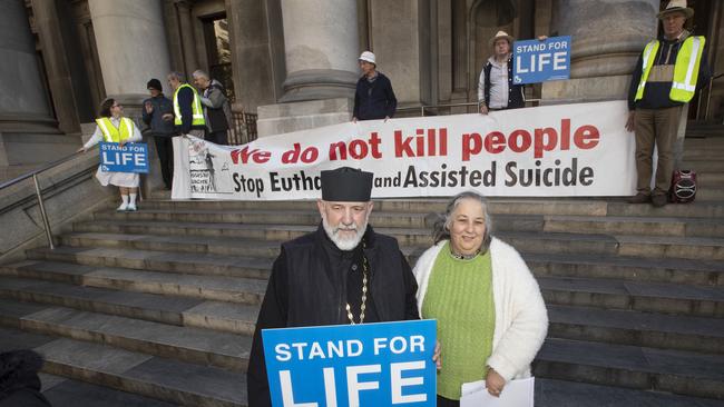 Father Barnabas from the Saints Elizabeth and Barbara Orthodox Church and Poppy Vivian at on the steps of Parliament house on Wednesday night, at a rally against the euthanasia bill. Picture Simon Cross