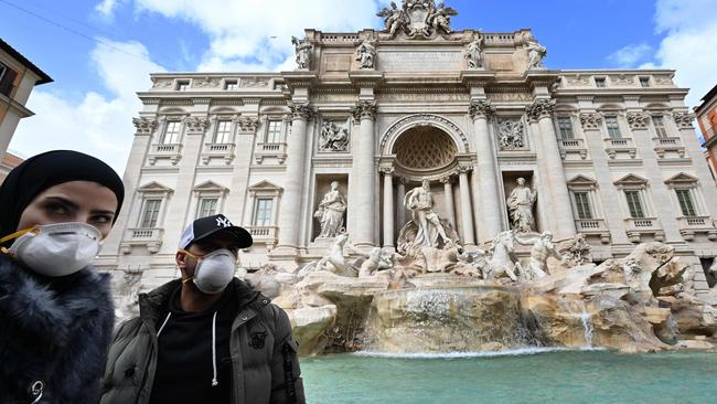 Tourists wear protective masks at the Trevi fountain in Rome Picture: AFP