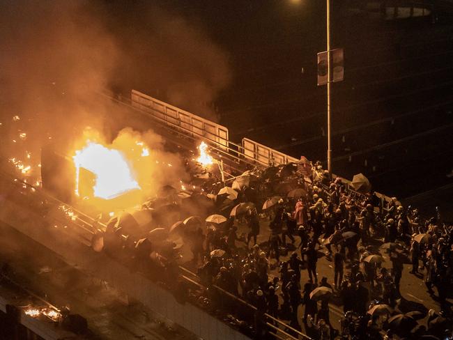 A police personnel vehicle is on fire as protesters throw fire bombs on a bridge at The Hong Kong Poytechnic University during anti-government protests. Picture: Anthony Kwan/Getty