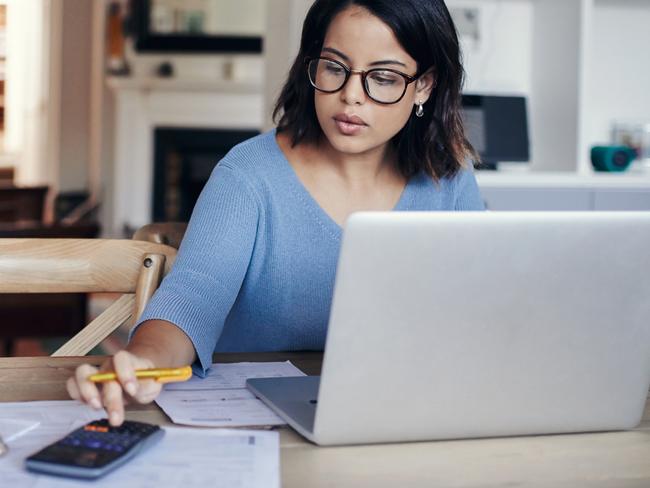 MONEY ISTOCK -  Shot of a young woman using a laptop and calculator while working from home Picture: Istock