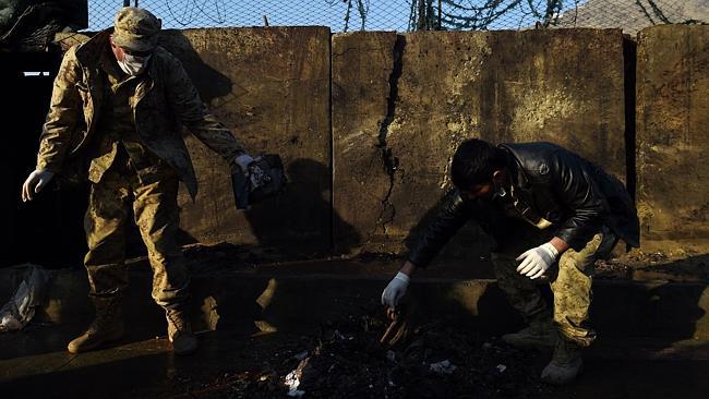 Afghan security personnel investigate after the suicide attack in Kabul.