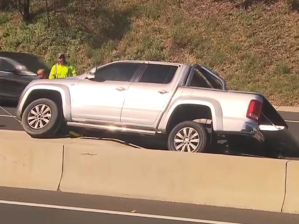 A man has been arrested after driving down the wrong side of the M5 and crashing his ute on a concrete dividing barrier. Picture: Channel 7