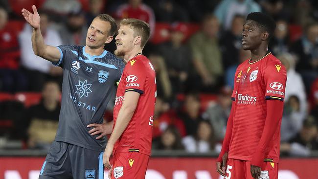 Sydney’s Alex Wilkinson and Adelaide’s Ben Halloran watch a replay of the goal of Al Hassan Toure (right) as VAR confirmed it. Picture: Sarah Reed