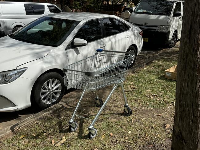 A shopping trolley left close to a parked car on Cairds Ave, Bankstown, on Tuesday. Picture: Canterbury-Bankstown Express