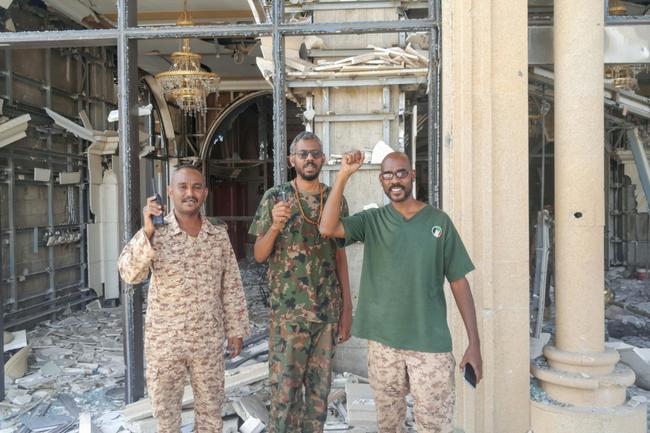 Fighters loyal to Sudan's regular army pose for photographs at the battle-damaged presidential palace in Khartoum after its recapture from the paramilitary Rapid Support Forces