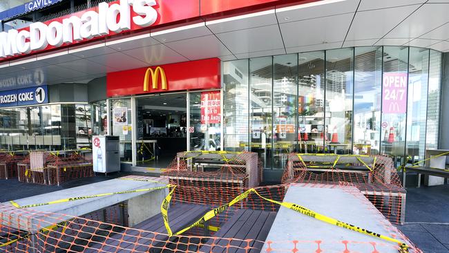 Dining tables are taped off outside a McDonald’s restaurant in Surfers Paradise. Picture: AAP.