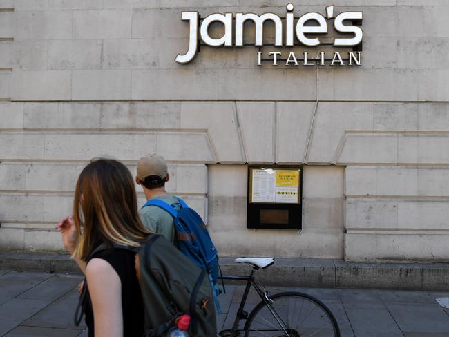 Pedestrians walk past a closed-down Jamie's Italian restaurant in Manchester, northern England. Picture: AFP