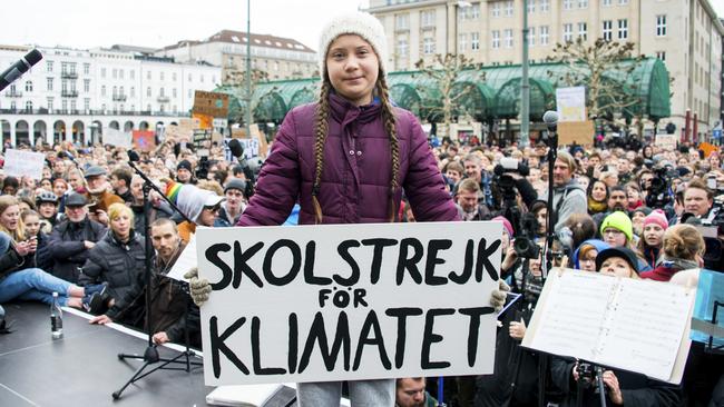 Swedish climate activist Greta Thunberg holds a slogan that translates to 'School Strike For The Climate’ at a protest rally in Hamburg, Germany on March 1. Picture: Daniel Reinhardt/AP