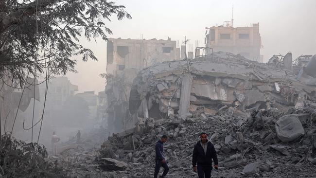 Men look for their belongings amid the rubble of buildings destroyed in Israeli airstrikes in the central Gaza Strip. Picture: AFP