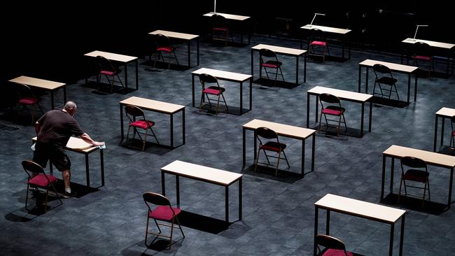 A man disinfects tables in an empty exam room at the Ancienne Belgique concert hall in Brussels. Picture: AFP)