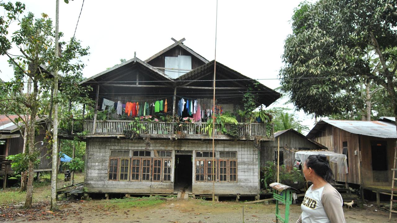 FOTO Indonesia’s New Capital City (IKN) - A mother, passing a simple house owned by a resident in the village of Bukit Raya, Sepaku District. This village is one of the areas affected by the New Capital City (IKN).