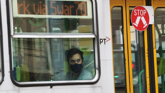 A commuter wears a mask while riding a tram on Swanston St. Picture: David Crosling