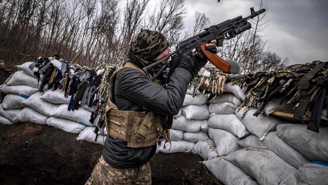 A Ukrainian serviceman shoots at a Russian drone with an assault rifle from a trench at the frontline east of Kharkiv on March 31. Picture: AFP