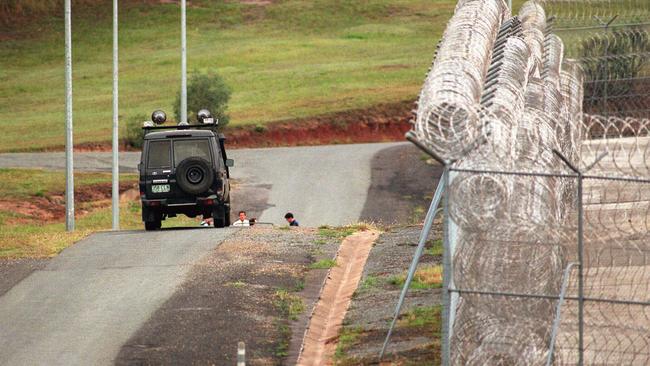 Pic: Nathan/Richter. -  Armoured car which had its headlights shot out during prison escape when  5 prisoners escaped from Sir David Longland prison Nov 05 1997 - Barbed razor wire fence - buildings motor vehicles crime qld escapees