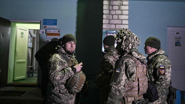 Ukrainian soldiers stand guard outside a kindergarten that was reportedly shelled in the settlement of Stanytsia Luhanska, Ukraine. Picture: AFP