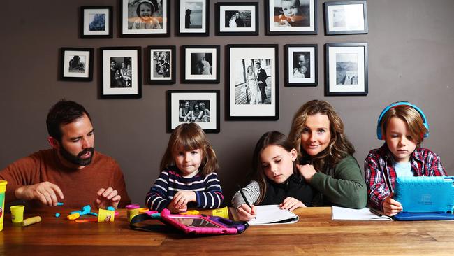 Mat and Kate Tinkler help their kids Audrey, Flynn and Margot with remote learning. Picture: Aaron Francis