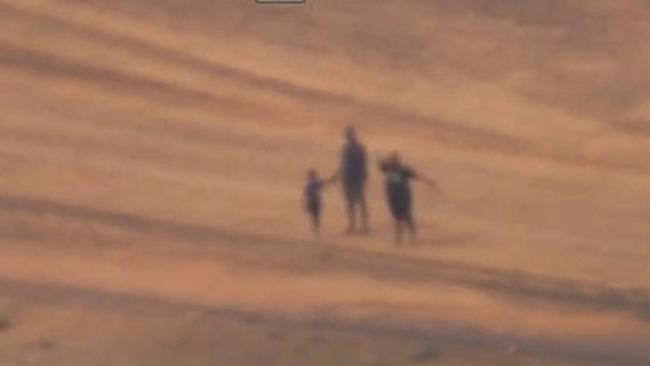 People stranded near Oodnadatta wave to the AMSA aircraft. Picture: AMSA