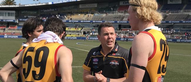 Josh Bourke talks to Dandenong Stingrays players during a break in this year’s TAC Cup grand final.