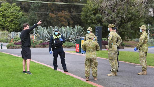 Police officers and soldiers patrol Treasury Gardens. Picture: William West/AFP.