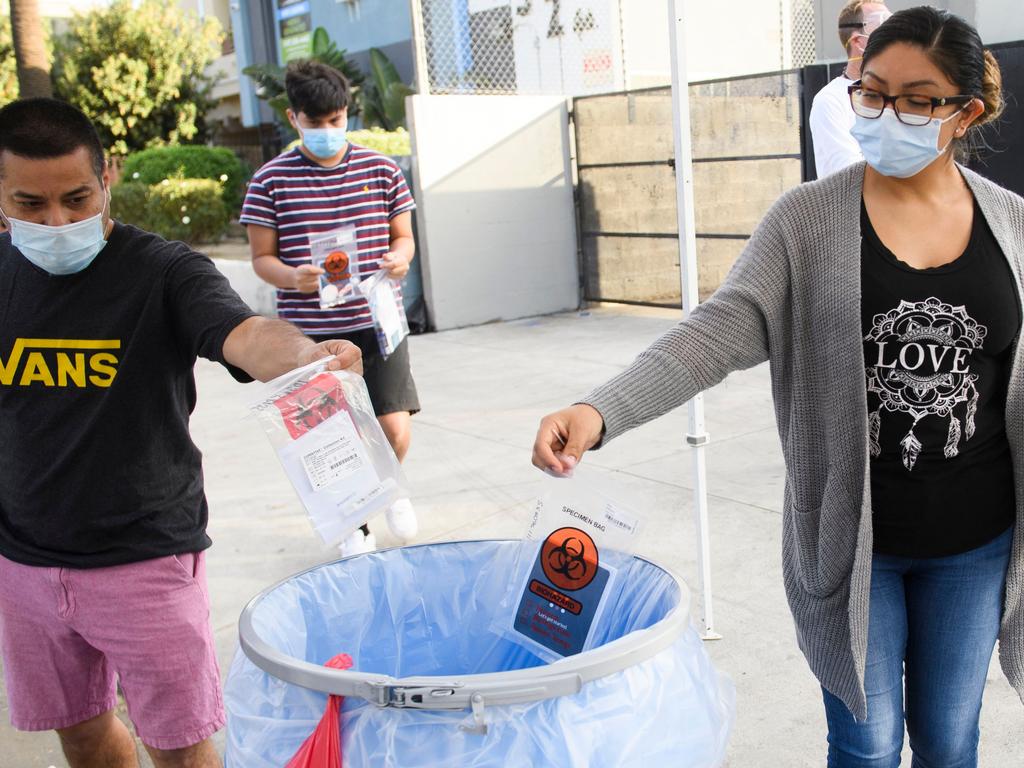 People drop off completed COVID-19 oral swab tests at a pop-up community testing site in Los Angeles. Picture: AFP