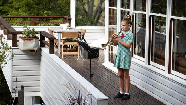 Taylor Grayson (11), pictured playing her trumpet on the balcony at her home in Avalon. Picture: Julian Andrews.