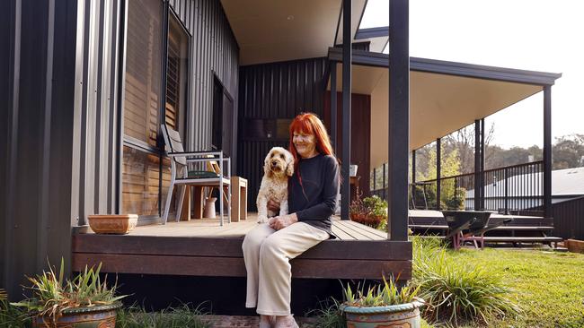 Joy Murdoch with her dog China in her new home, which she built after fire destroyed her original home in Mogo. Picture: Sam Ruttyn