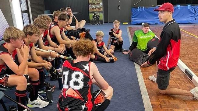 Coach Jai Cass talks tactics with the Rockhampton under-16 boys indoor hockey team.