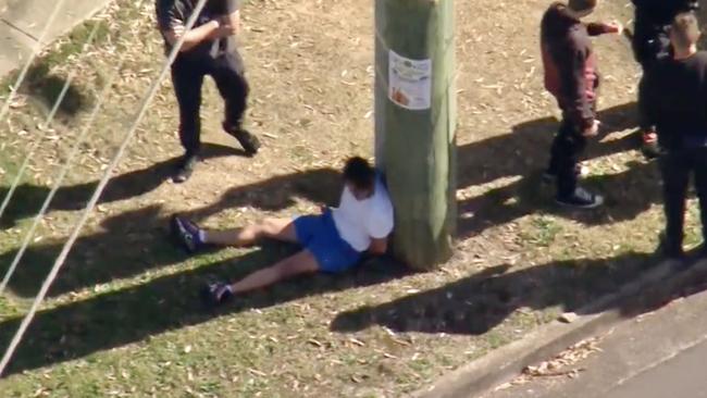 A man who was pulled from the car by police sits under arrest after the chase came to an end. Picture: 9 News